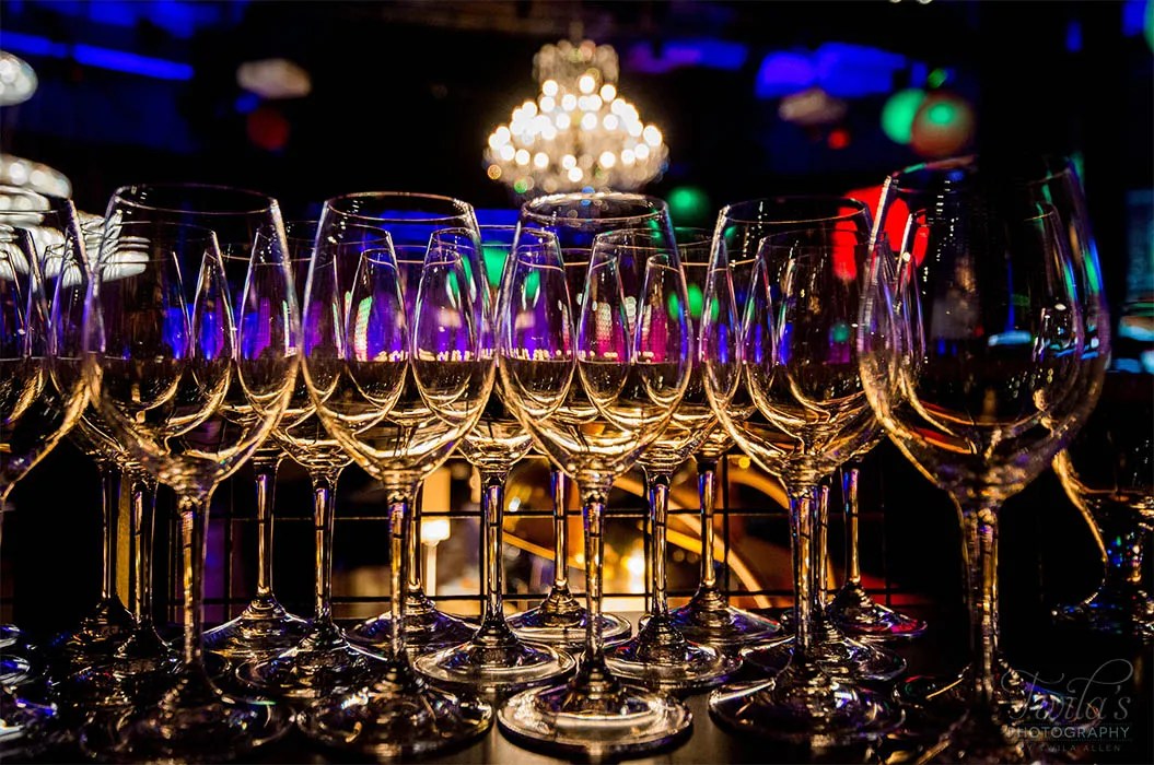Rows of empty wine glasses arranged for an event, illustrating digital solution content experiences.