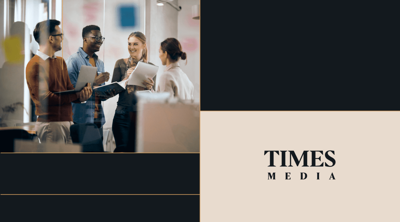 Four colleagues discussing editorial workflow with a Times Media logo, highlighting digital solution integration.