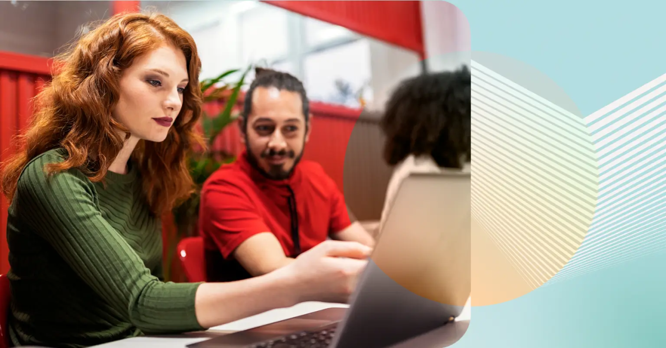 Two coworkers examining a laptop screen together.