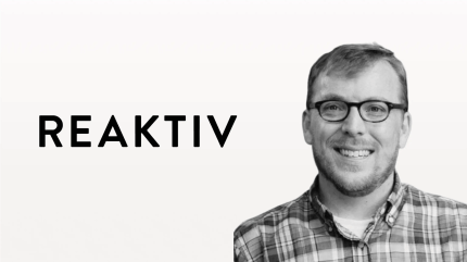 Smiling man in glasses with REAKTIV digital solution branding, representing a content publishing platform.