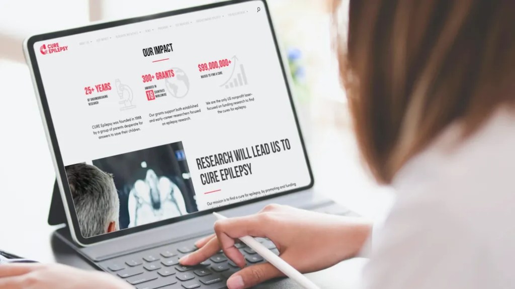 Person viewing research impact and analytics on a Cure Epilepsy digital solution dashboard on tablet.