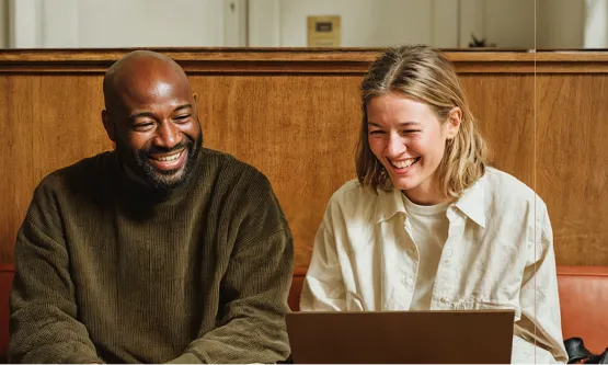 Coworkers smiling during a collaborative work session.