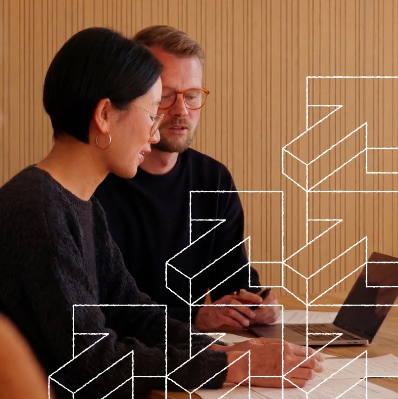 Two colleagues collaborating with a laptop and documents, representing enterprise content planning and structured workflows on WordPress VIP.