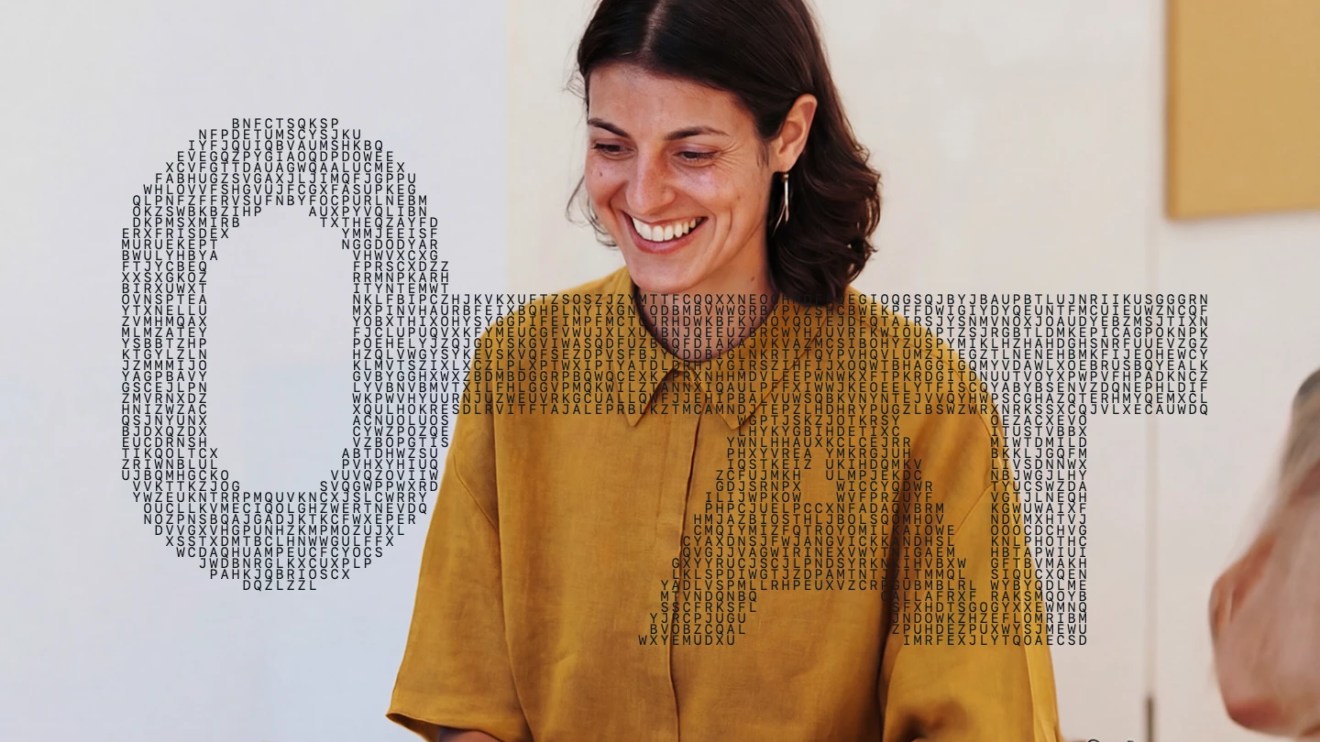 Smiling woman beside a key formed from letters, representing how structured, findable content supports AI search visibility.