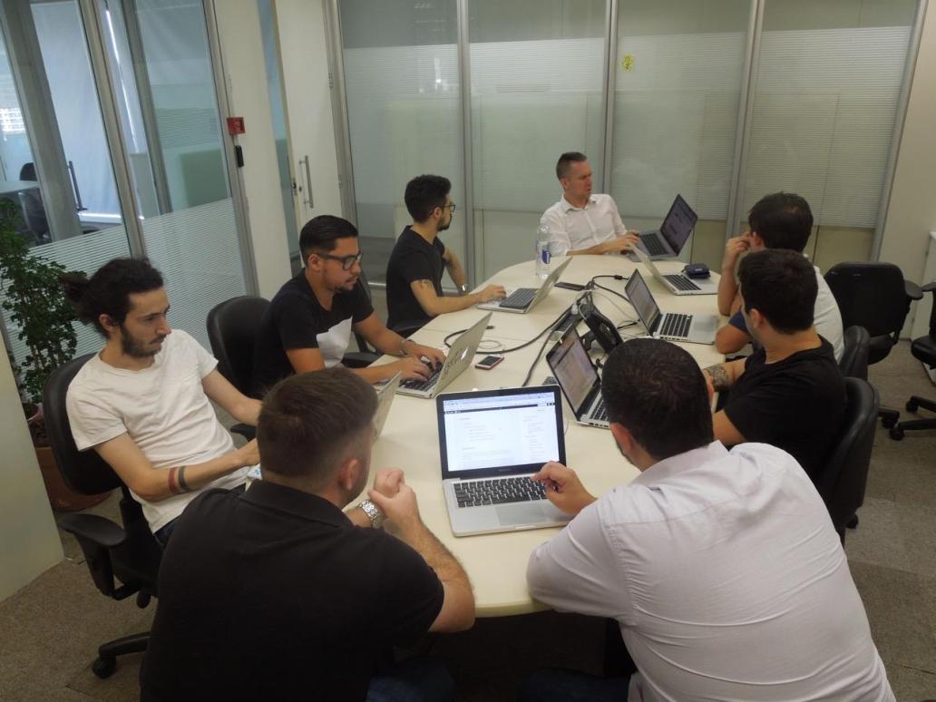 A group of people sitting at a table working on laptops