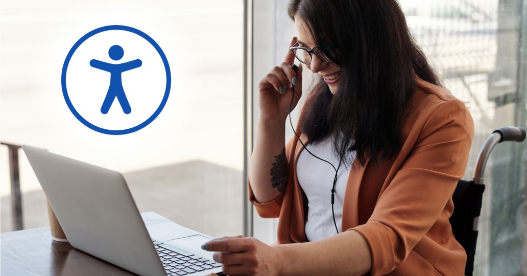a long haired person smiling at a laptop screen while pointing their finger to their temple and sitting in a wheelchair, an illustration of a stick figure surrounded by a blue circle sits in the corner