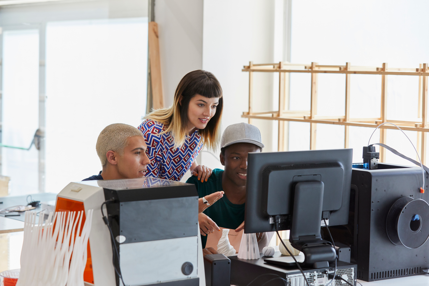 Young coworkers discussing over project while looking at computer