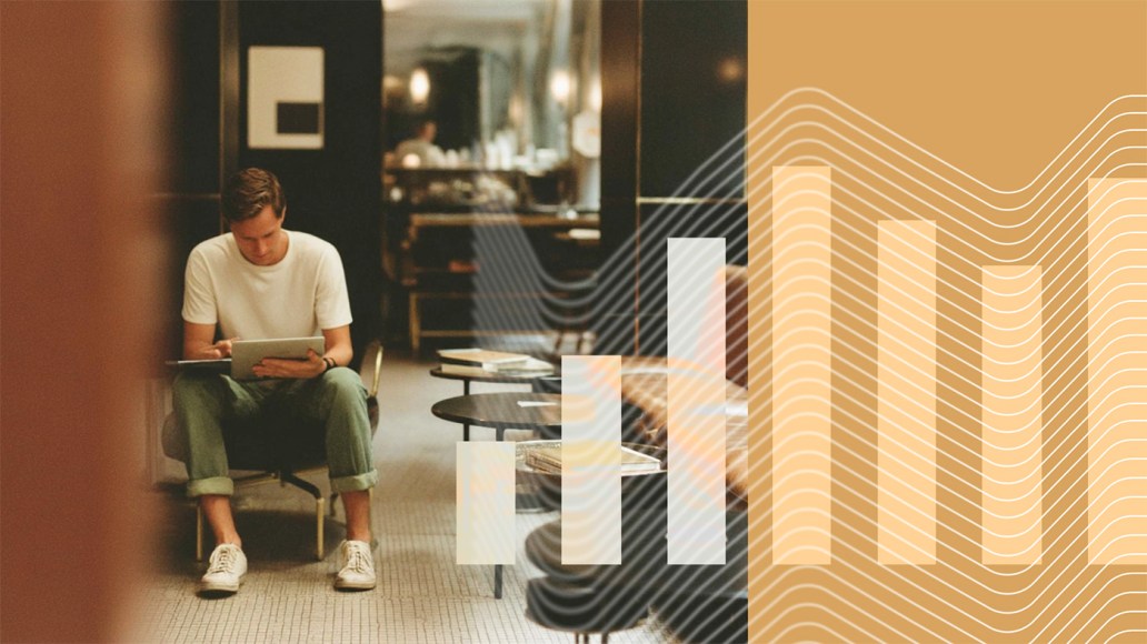 A man wearing a white t-shirt and rolled-up green pants sits in a lounge area, focused on a tablet. The background shows a modern, softly lit interior with dark walls and tables. Overlaid on the right side of the image are semi-transparent bar graphs and wavy lines in shades of orange and white, blending data visualization with the real-world scene.