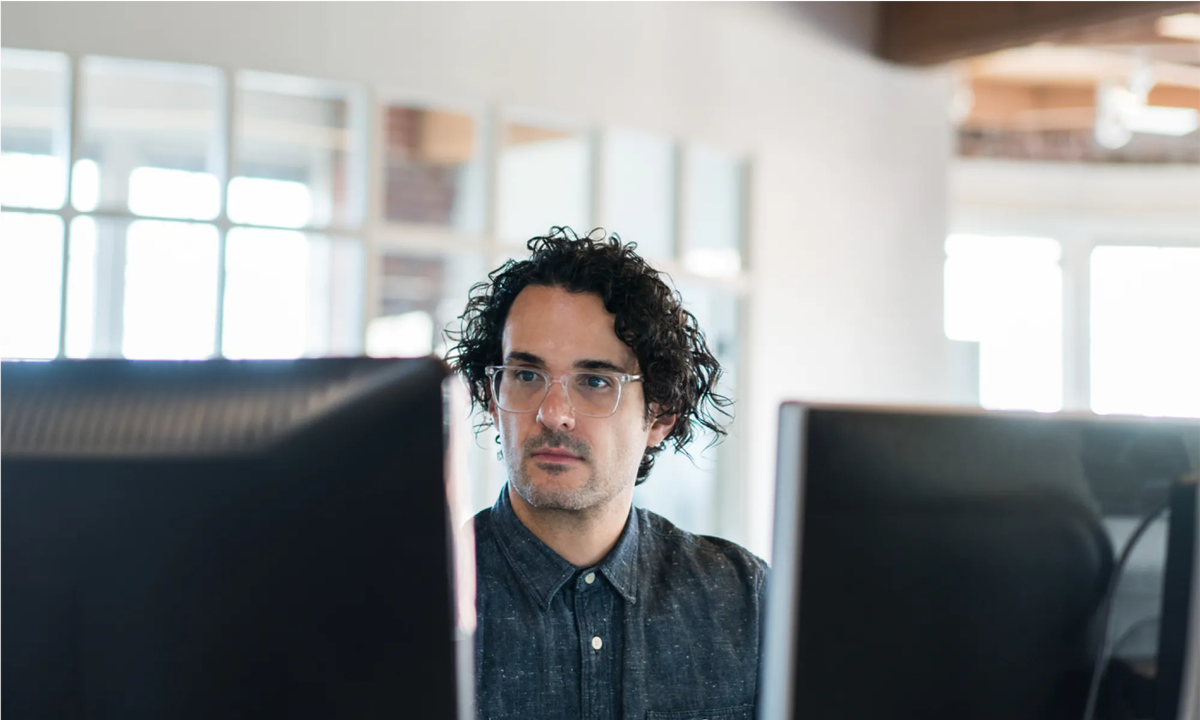Man with dark hair and glasses working on his content management system
