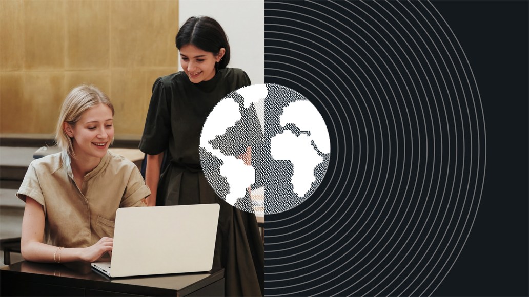 Two colleagues working at a laptop alongside a world map graphic, illustrating an enterprise localization strategy supporting multilingual workflows across regions.