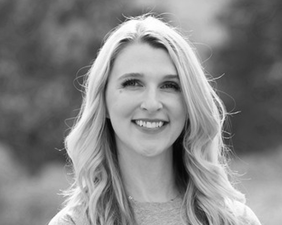 Smiling woman with long, wavy blonde hair, outdoors in black and white, embodying the fresh energy of the Future of the Web 2026.